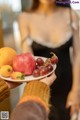 A woman holding a plate of fruit in her hands.