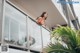 A woman in a red bikini standing on a balcony.