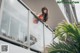 A woman in a red dress standing on a balcony.