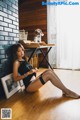 A woman sitting on the floor next to a table.