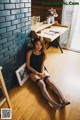 A woman sitting on the floor in fishnet stockings.