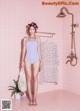 A woman in a bathing suit standing in a bathroom.