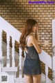 A woman in a blue dress standing on a stairway.