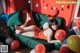 A woman laying on a couch surrounded by balloons.