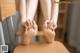 A woman sitting on a chair with her feet on the table.