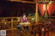 A woman sitting at a wooden table on a deck.