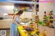 A woman in a blue dress preparing food on a table.