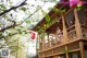 A woman standing on the balcony of a wooden house.