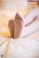 A close up of a person's feet on a bed.