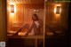 A woman sitting on a bench in a sauna.