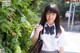 A young woman in a school uniform posing for a picture.