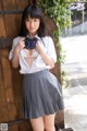 A woman in a school uniform posing for a picture.