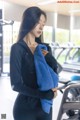 A woman in a black shirt is holding a blue towel.