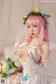 A woman in a wedding dress with pink hair and a flower crown.